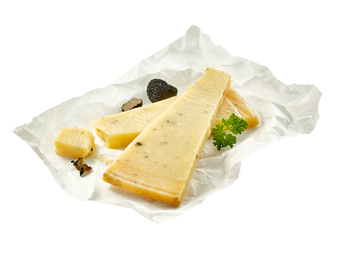 Aufgeschnittener Hartkäse mit Trüffel auf weißem Papier, garniert mit Trüffel und Petersilie